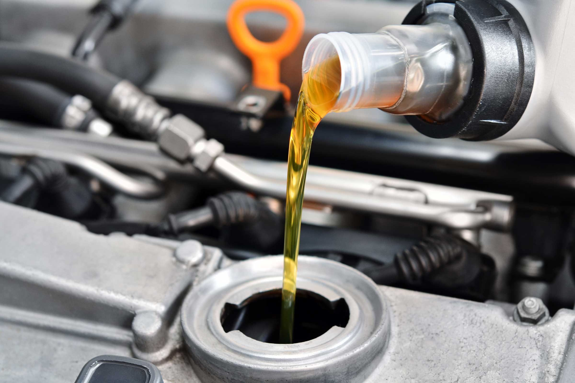 close up of pouring liquid into a car engine