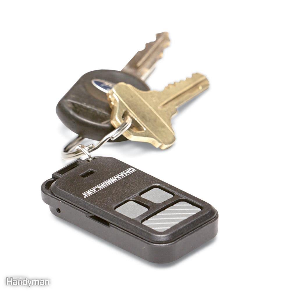 Keychain holds two metal keys and a black remote with buttons, labeled "Chamberlain," against a white background.