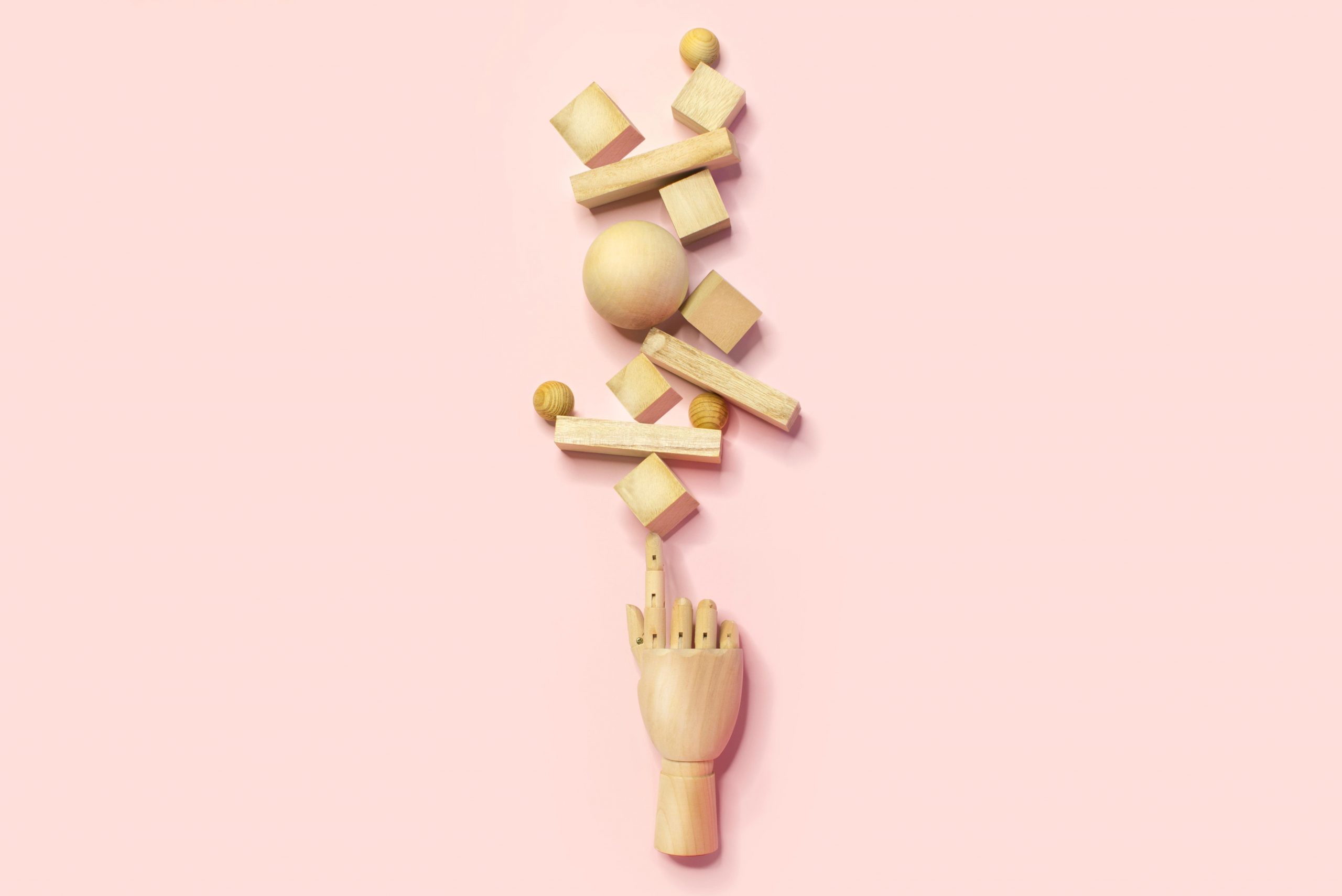 wooden hand balancing many different shapes and sizes blocks. multitasking concept.