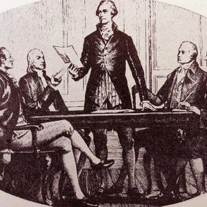 A group discusses a document around a table, with a standing man reading, in a historical setting.