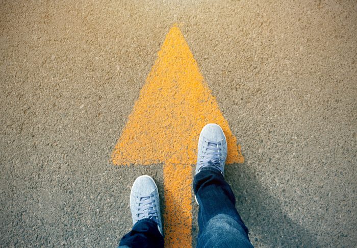 Feet and arrows on road.