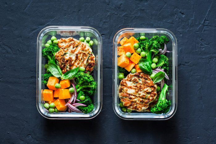 Healthy balanced lunch box. Grilled chicken zucchini burgers with broccoli, pumpkin, green pea salad on a dark background, top view. Office food lunch healthy lifestyle concept