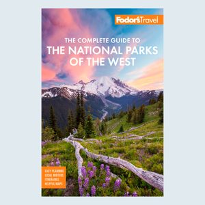 Guidebook cover; features snowy mountain, vibrant sky, lush green landscape with flowers. Text: 