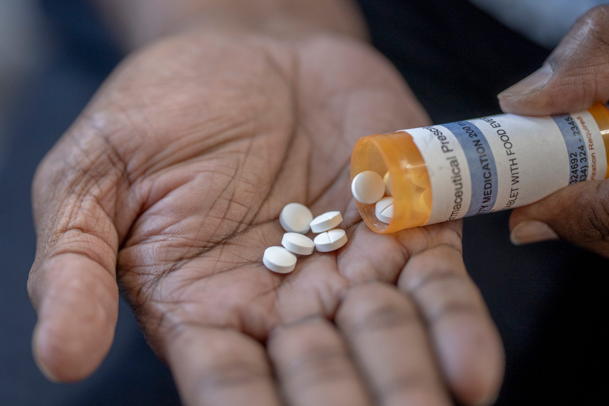Mature male pouring medicine into his hand