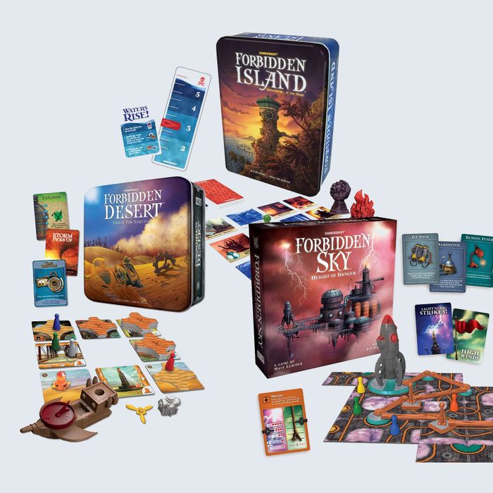 Three board games are displayed with components organized around their boxes: 