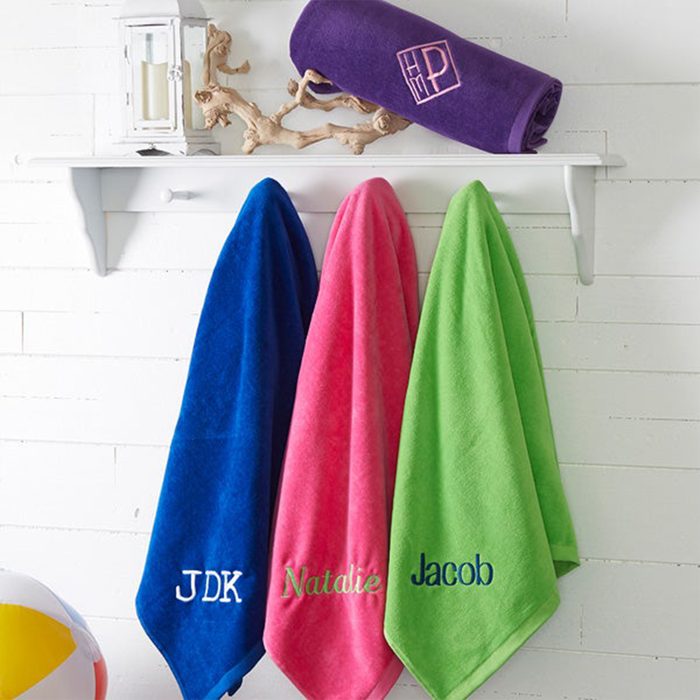 Towels hang on pegs, embroidered with names 