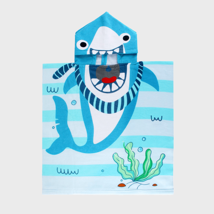 A blue hooded towel displays a cartoon shark with an open mouth, set against a background of horizontal aqua stripes and seaweed.