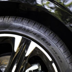 A car tire displays size specifications, 