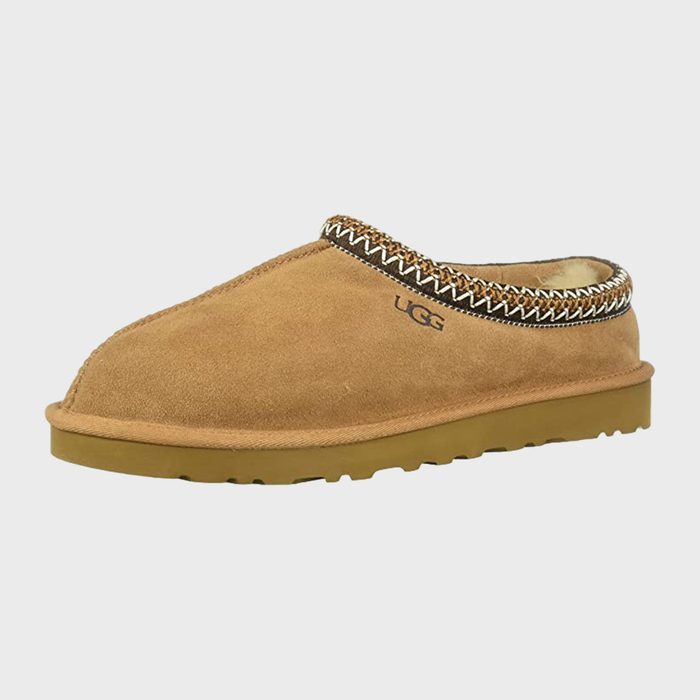 Camel-colored suede slipper with patterned trim, resting on a light gray background. 