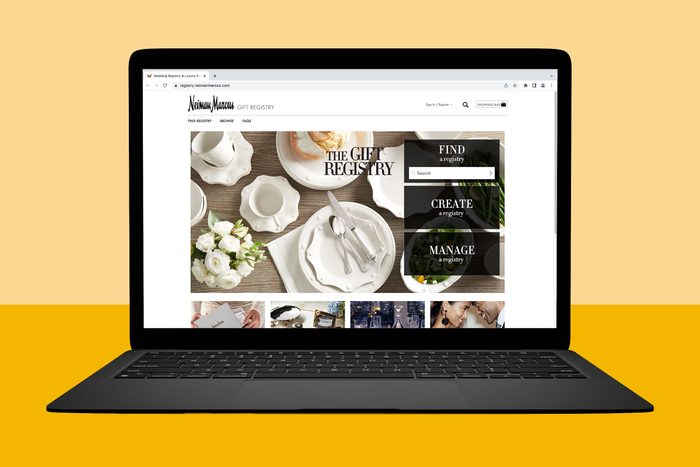 Laptop displays Neiman Marcus gift registry webpage featuring white tableware and floral arrangement; options to find, create, and manage a registry are visible.