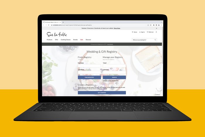 Laptop displaying a â€œWedding & Gift Registryâ€ website page; fields for name, email, and buttons for finding or managing a registry. Beige and yellow backdrop.
