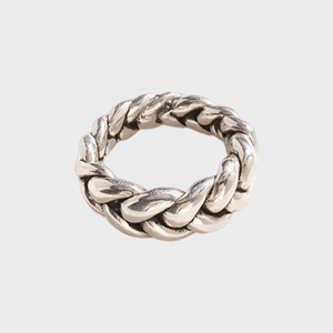 Silver braided ring lies stationary on a plain white background.