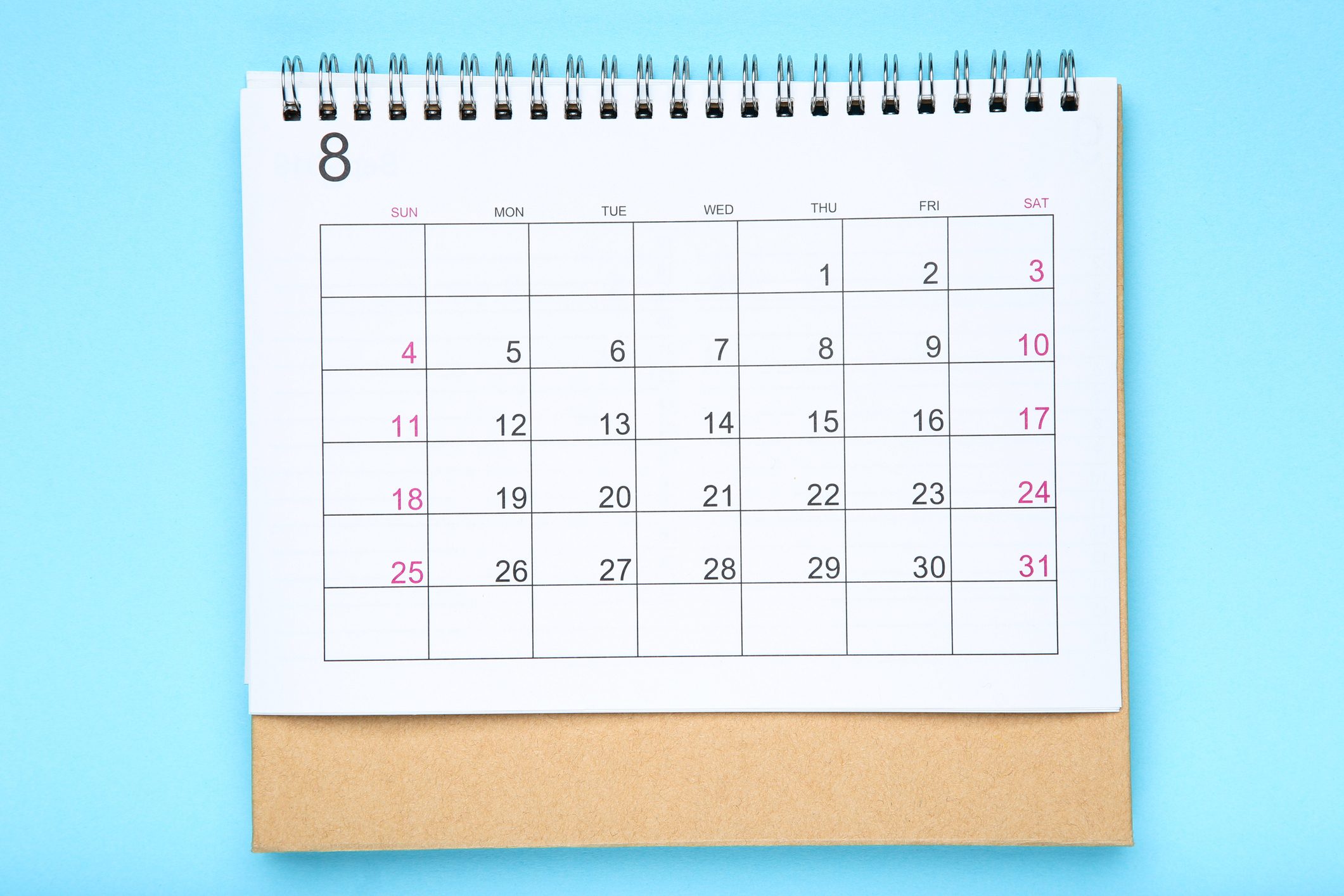 A spiral-bound calendar displays August dates, set against a blue background.
