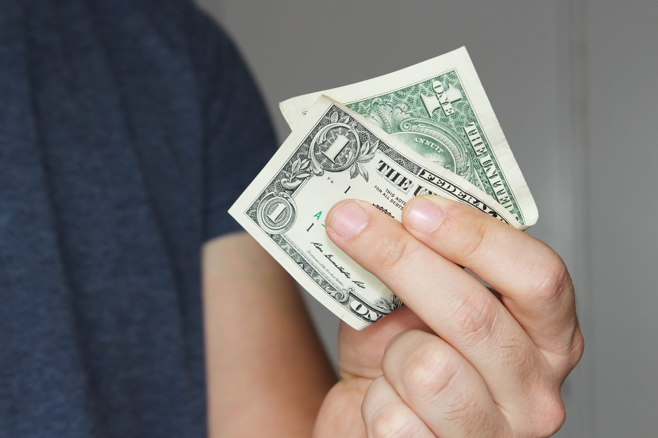 A white male holding a one dollar note.