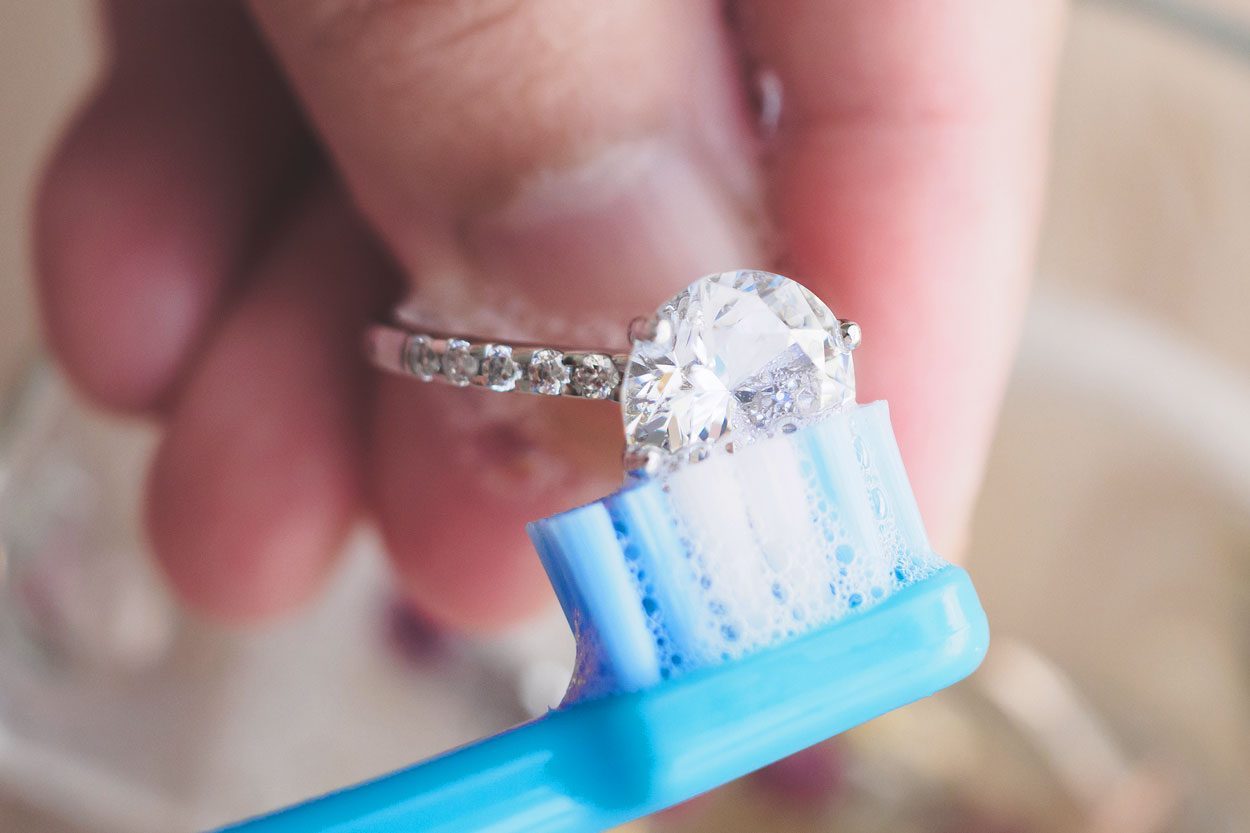 Jeweller Hand Cleaning And Polishing Vintage Jewelry Diamond Ring Closeup