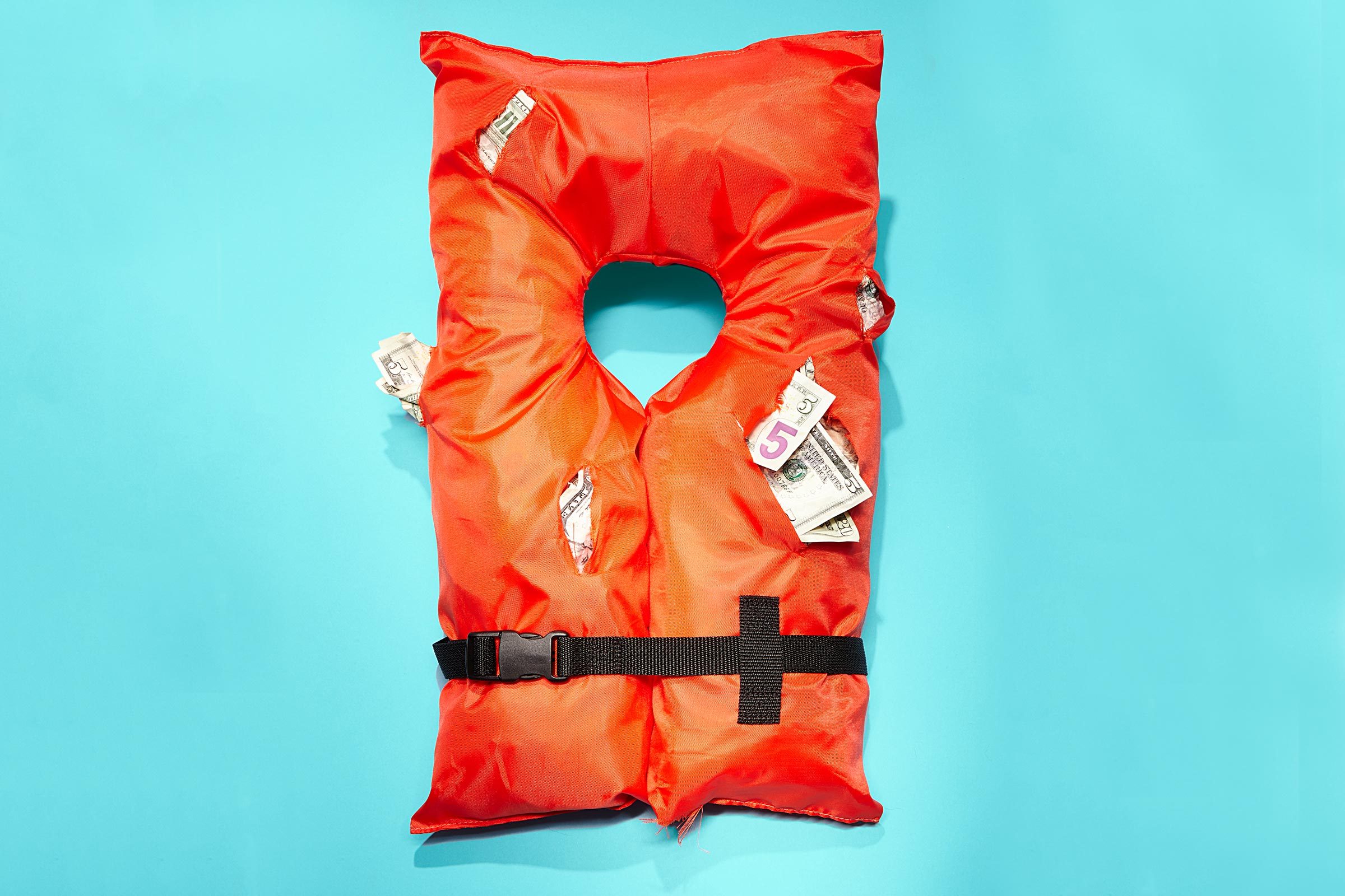 Orange life jacket filled with U.S. dollar bills, set against a plain blue background.