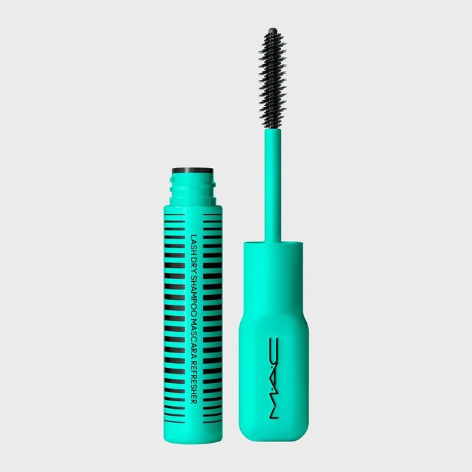 Mascara brush standing upright, cap open beside turquoise tube, reading 