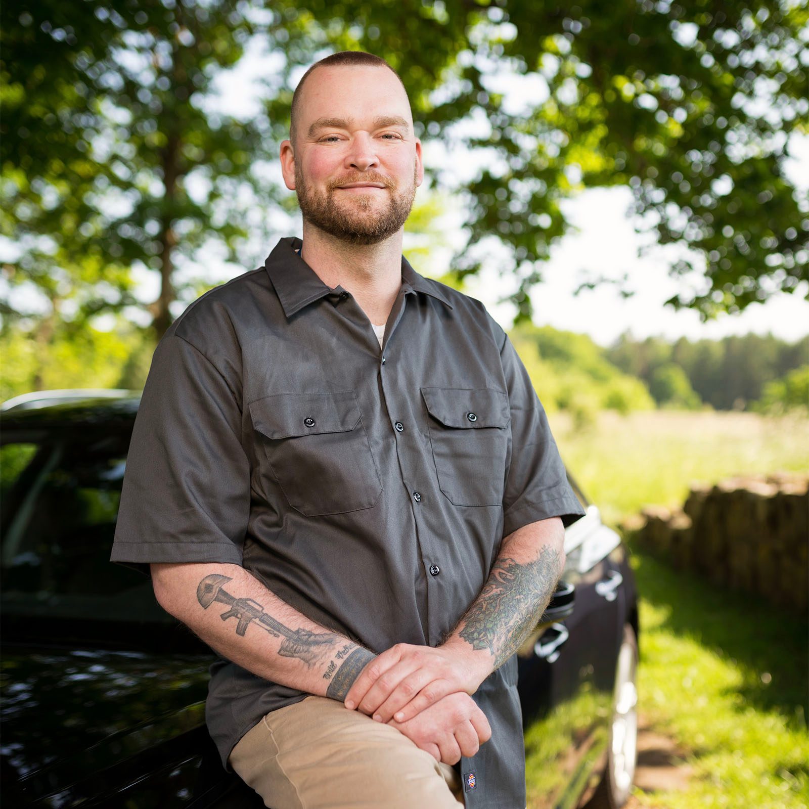 Uber driver Timothy Letts smiling and standing in front of his car