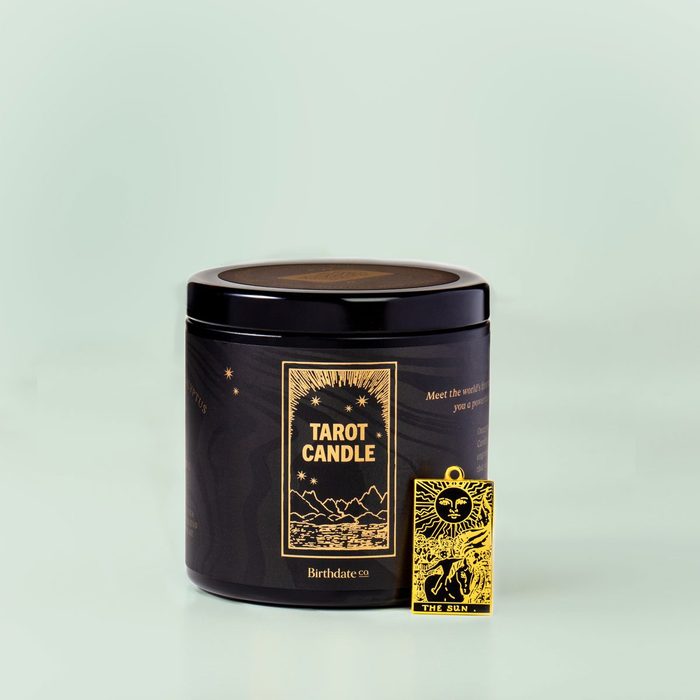 Candle container sits on a surface; labeled 