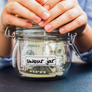 Hands hold a glass jar labeled 