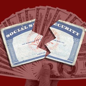 Social Security card appears torn over a spread of U.S. hundred-dollar bills against a solid red background.