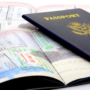 A U.S. passport lies open, displaying various immigration stamps on its pages, symbolizing international travel and documentation.