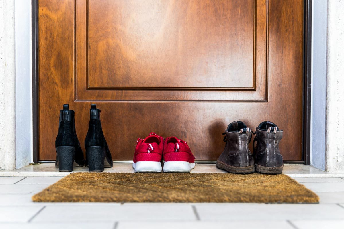 Common Mistake Can Ruin Your Floors This Winter - shoes removed and lined up outside house
