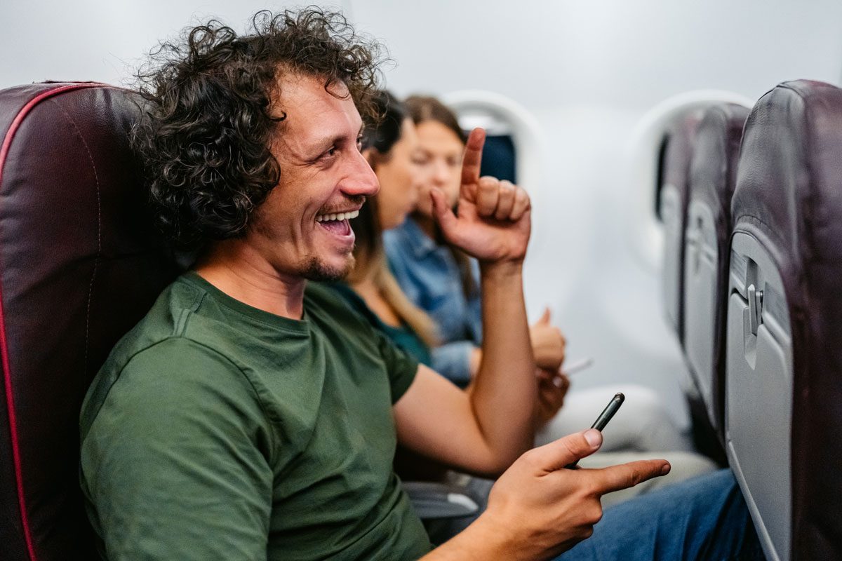 Young Man Listening To Music In An Airplane