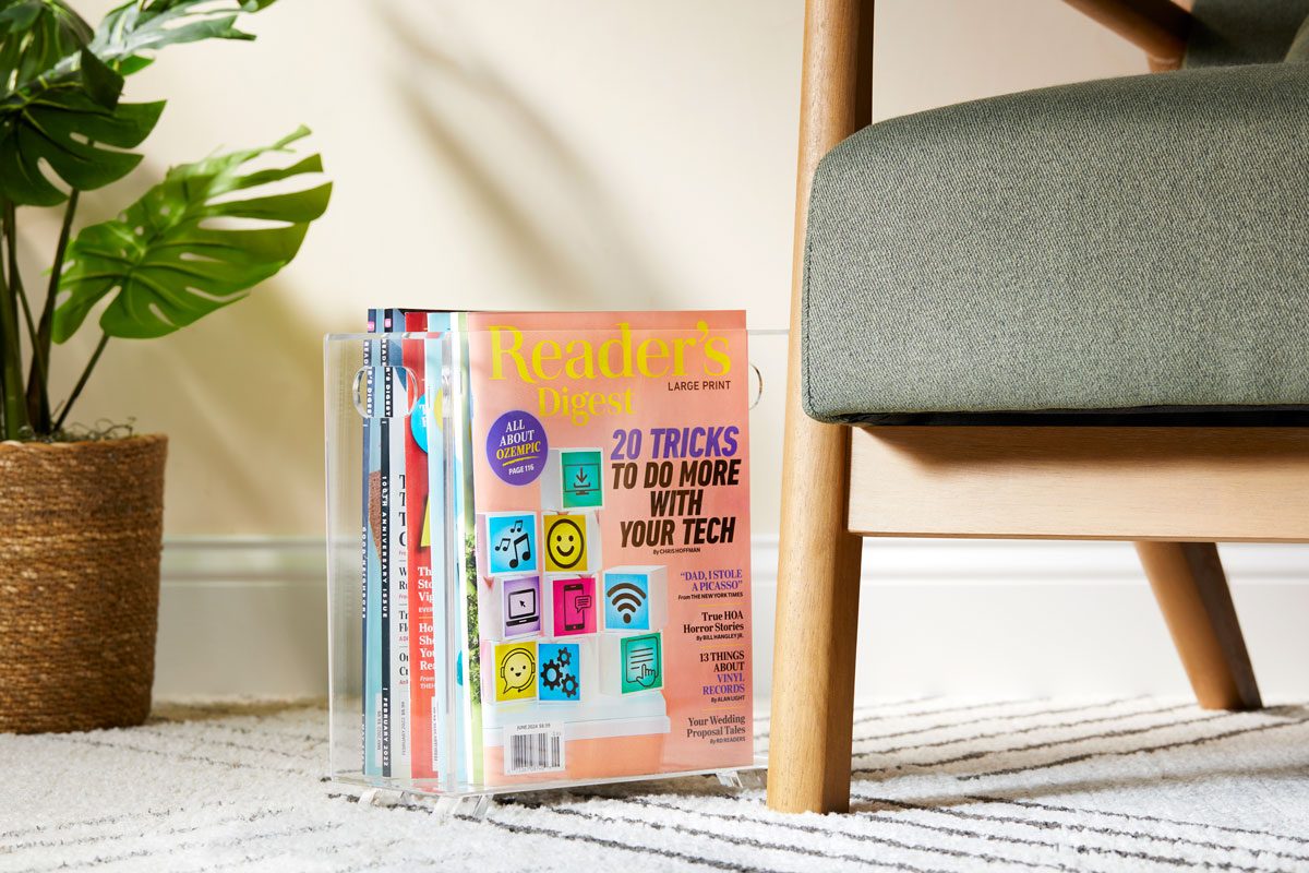 magazines gathered and styled in a clear magazine holder near a comfy chair