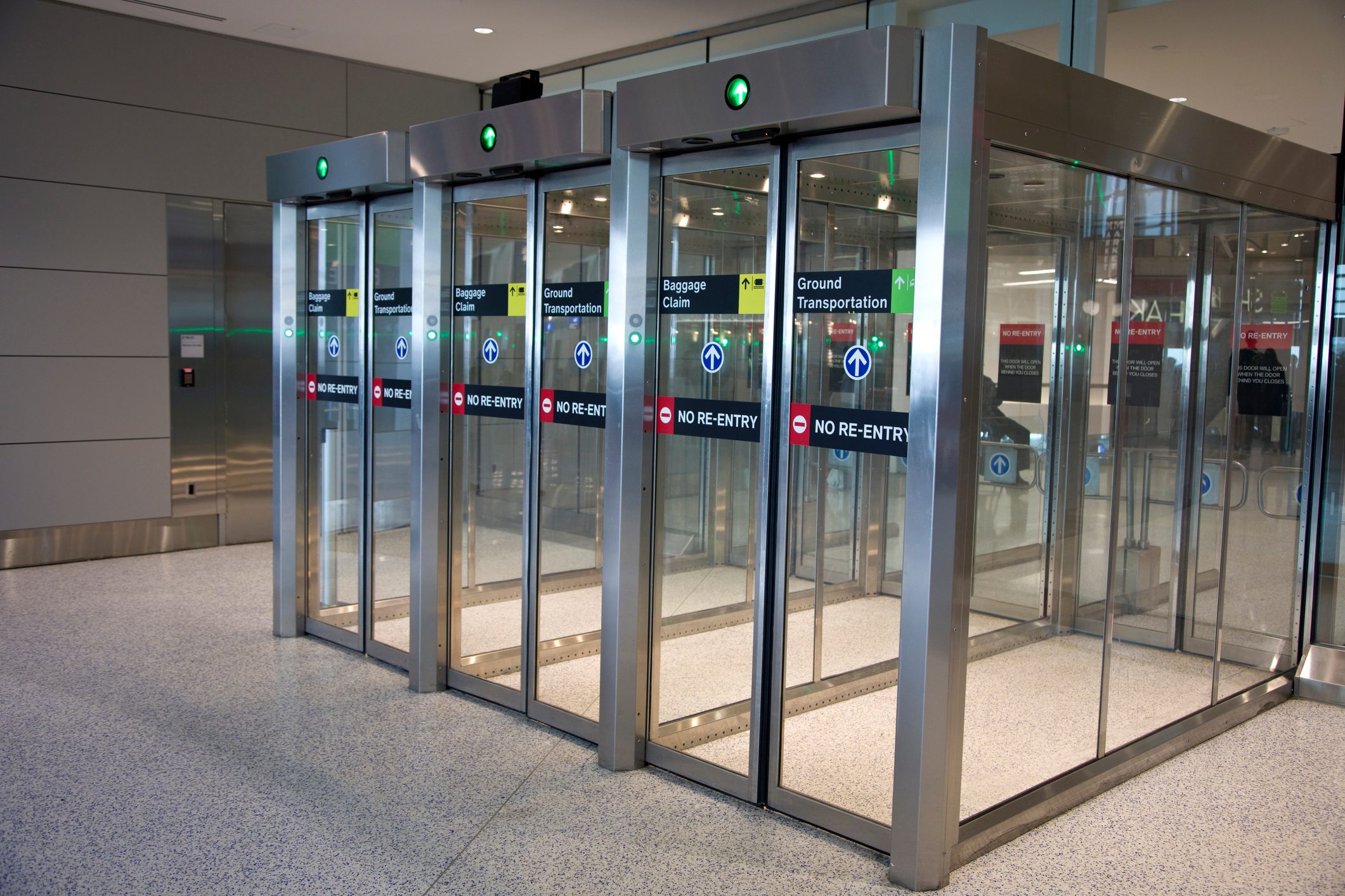 Airport security exit with three sets of automatically opening glass doors