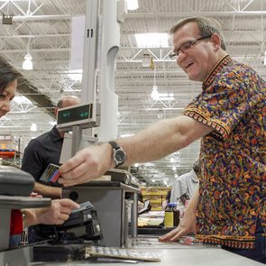 Mark Gilliam, a cashier at the San Francisco, Calif., Costco, helps Donna Fujii at his register
