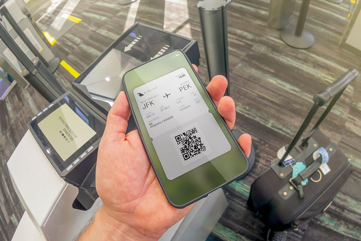 A happy tourist traveler backpacker male holding a smartphone cellphone with a Boarding digital pass