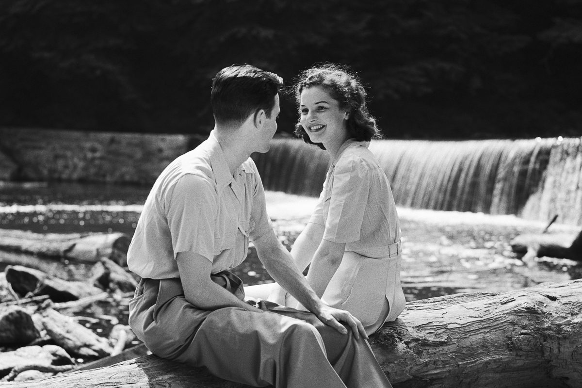 young couple sitting on a fallen log