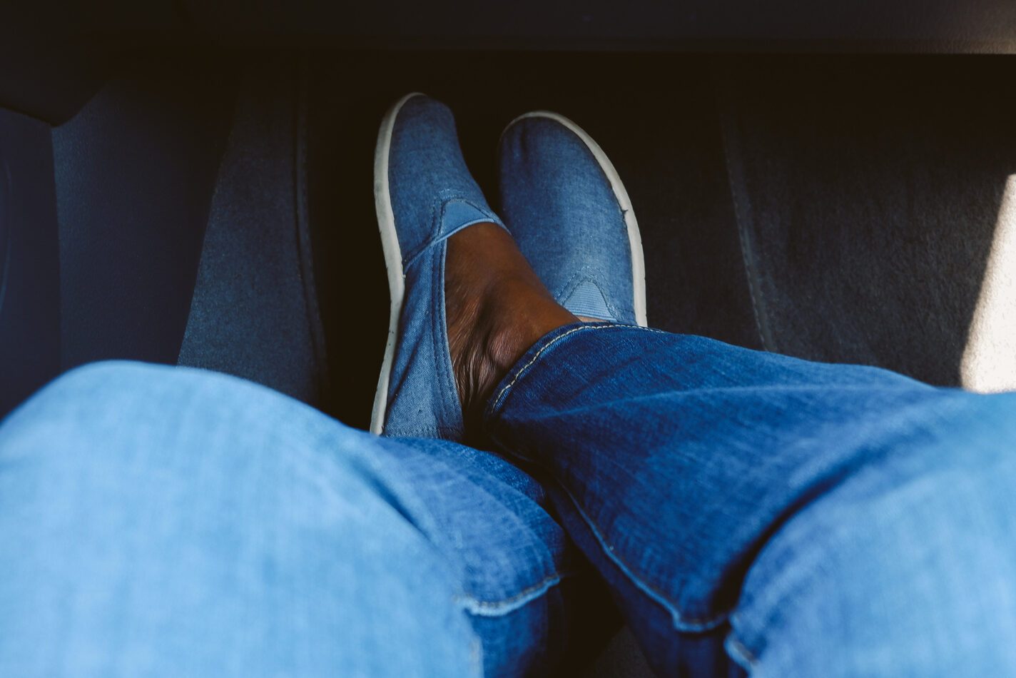 Woman Sits in Car With Feet Crossed