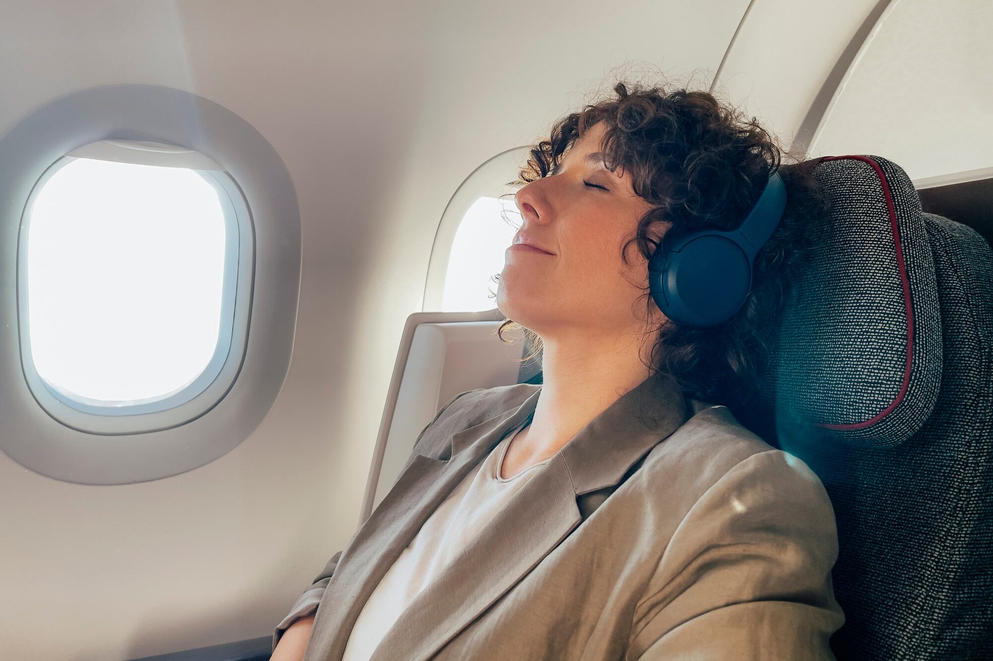 A Tired Businesswoman Taking A Nap While Travelling On Business Trip By Plane