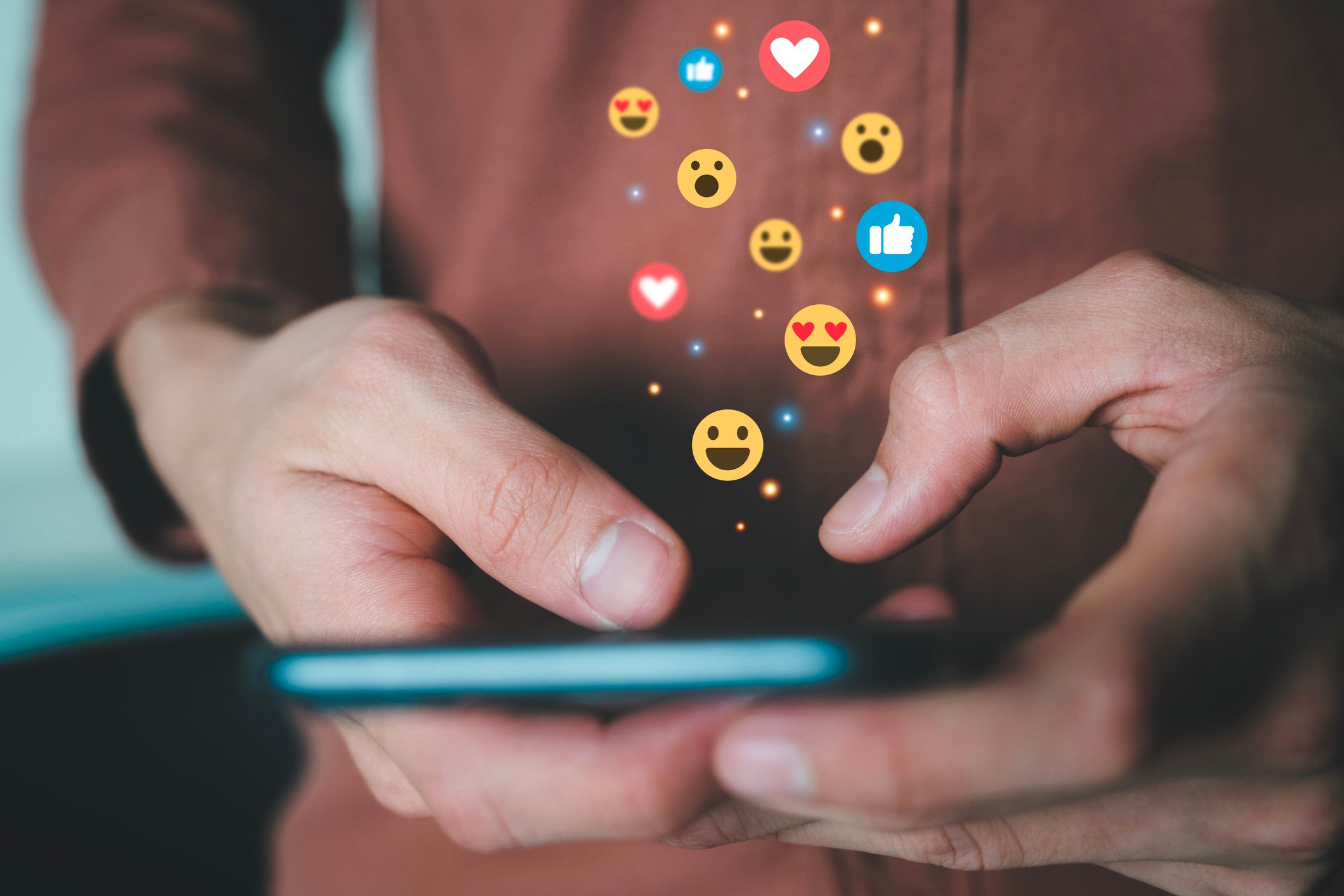 Man holding phone connecting with people using social media.