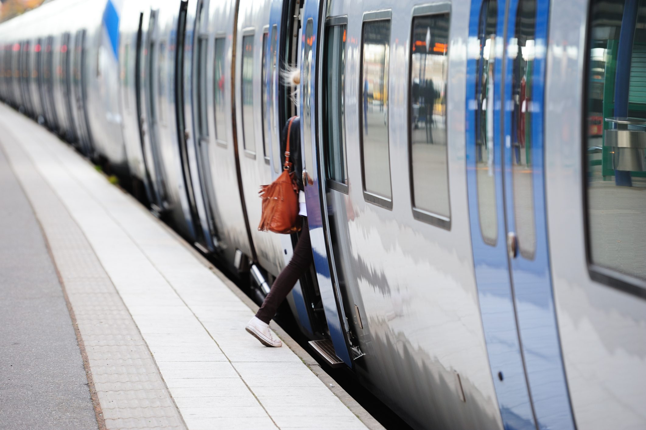 Girl entering train, daytime motion blurred picture