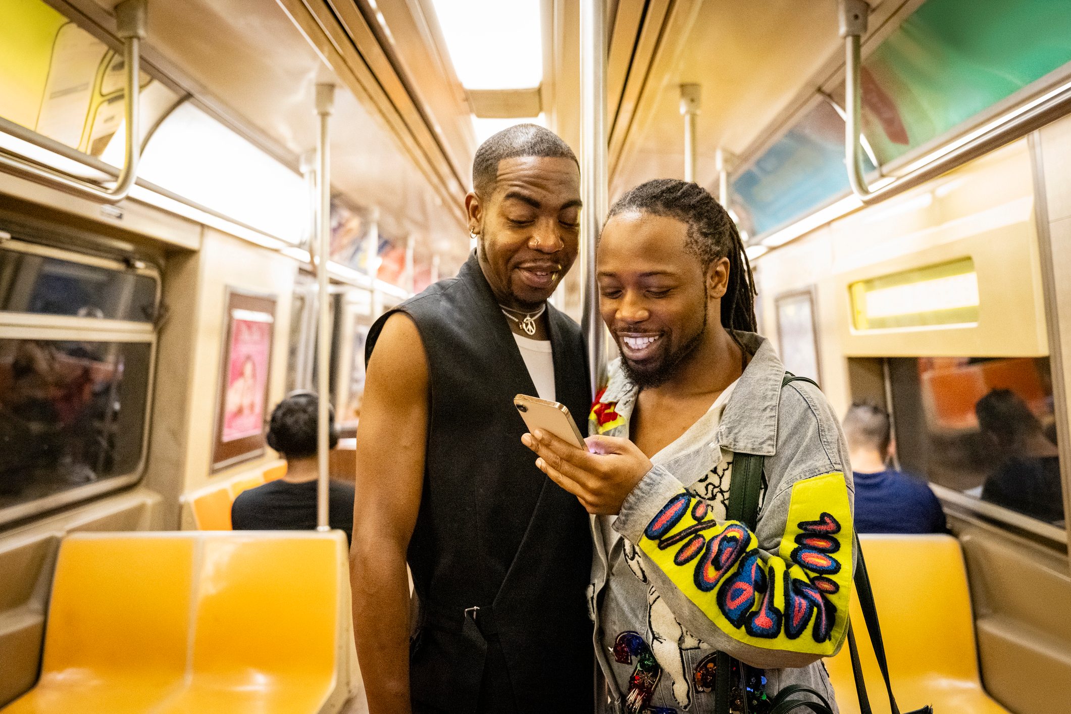 Black couple on New York subway using phone