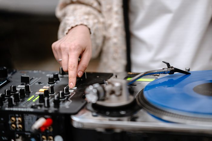 Female DJ mixing music on turntable and mixer at a live event