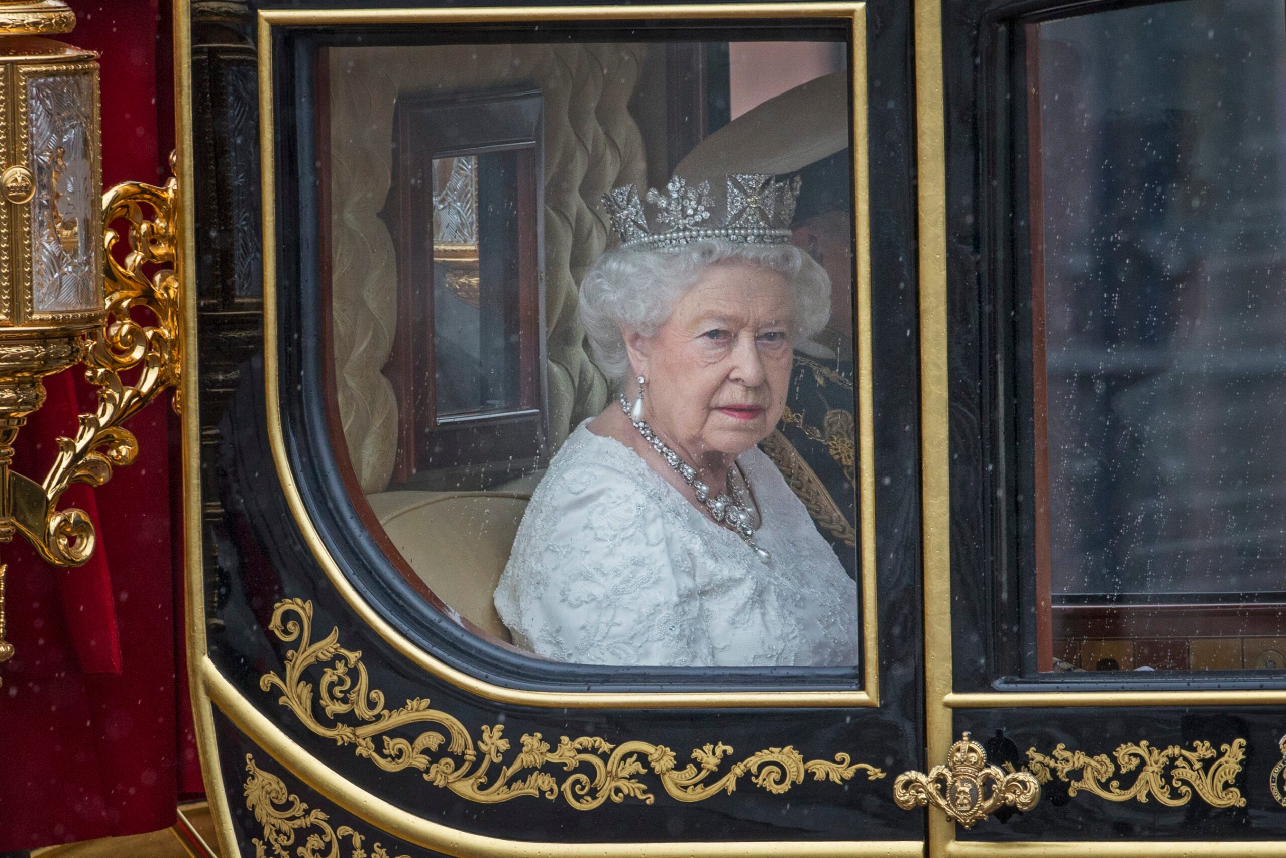 Queen Elizabeth looks out the window of a carriage