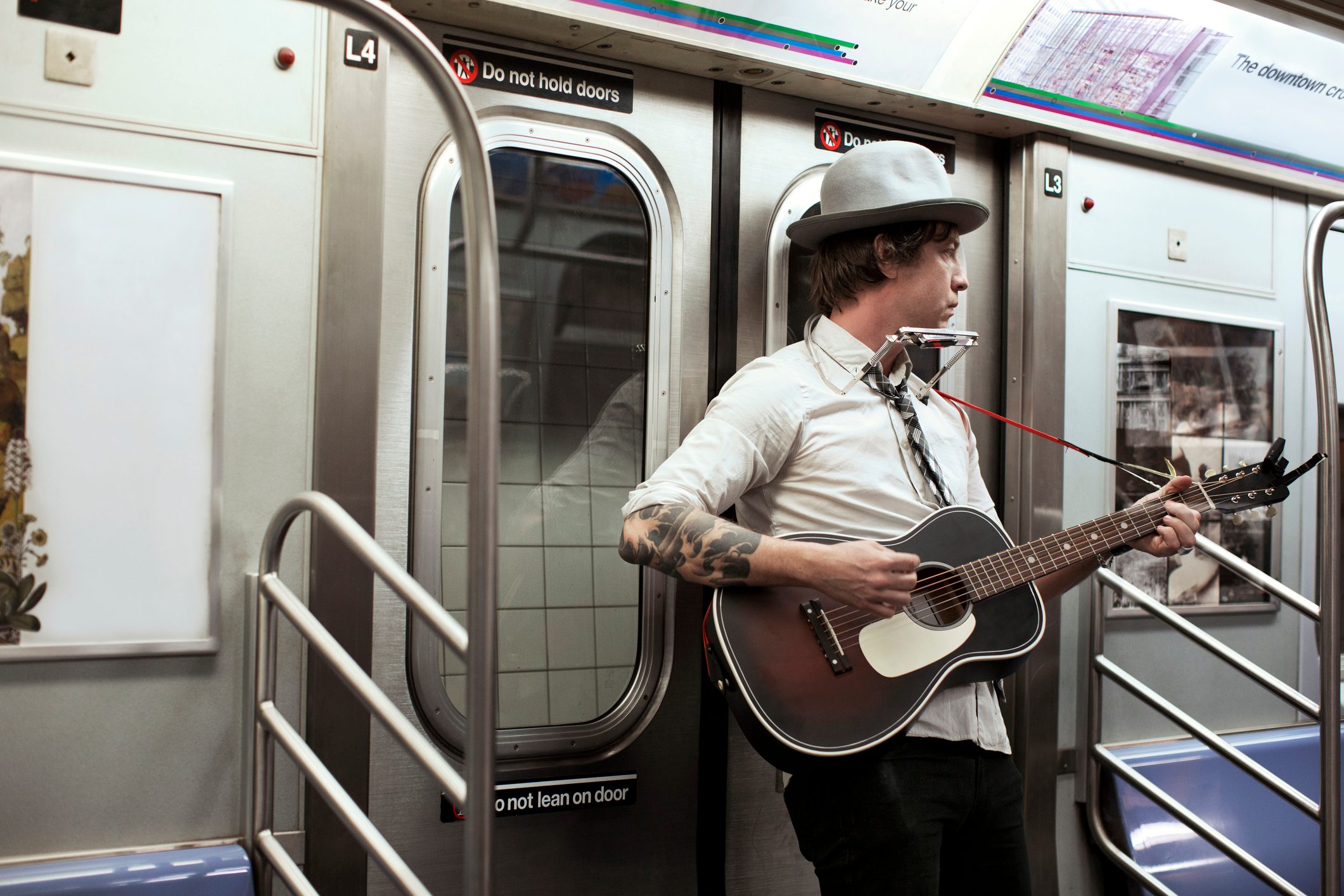 Street musician playing guitar in subway train