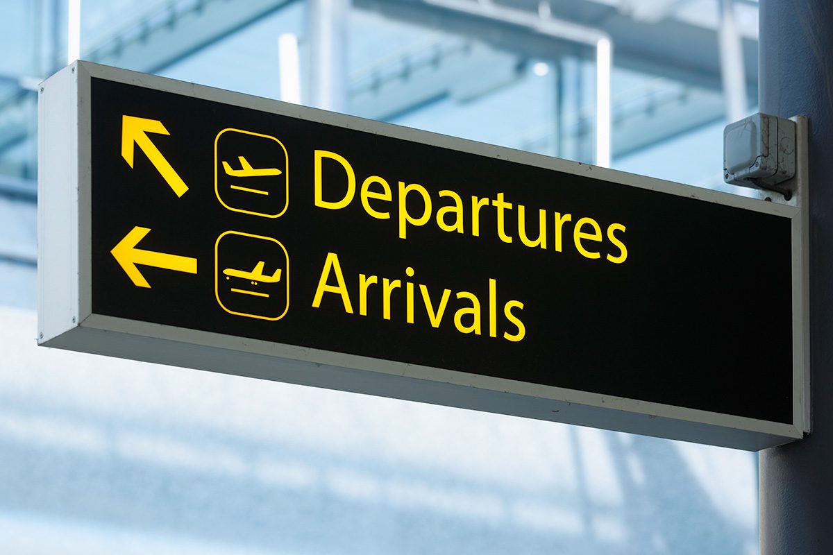 Sign pointing the way to Departures and Arrivals at an airport.