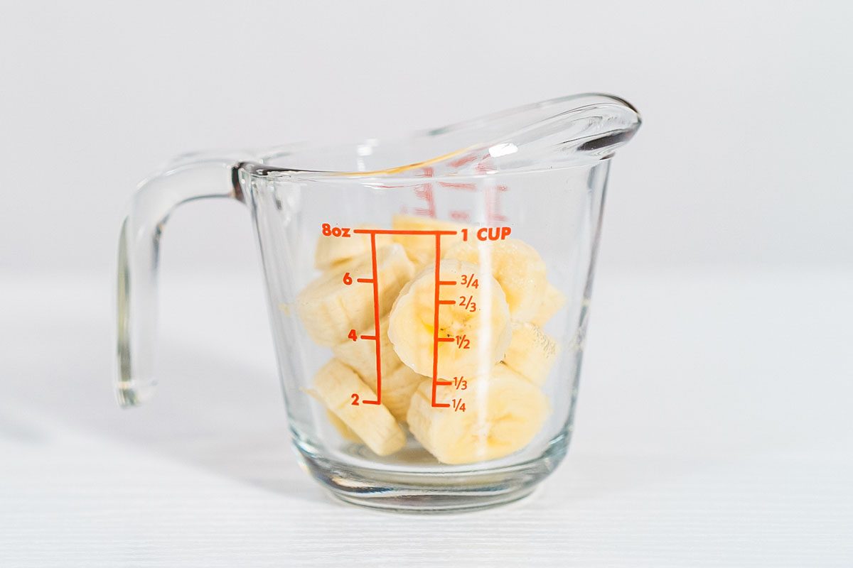 Slicing Riped Banana In A Glass Measuring Cup