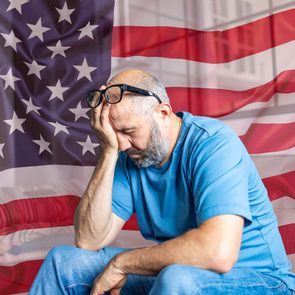 Stressed Man With Us Flag In Background