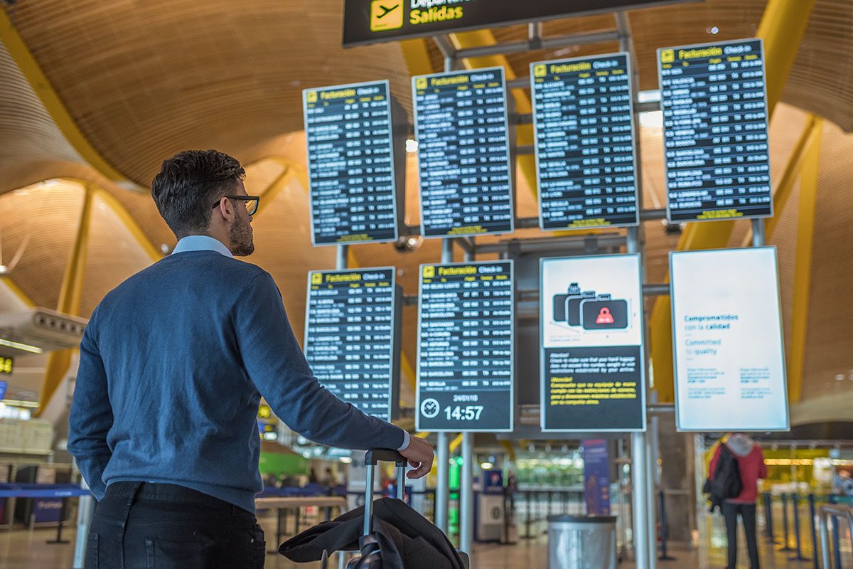 Man checking his flight on the timetable display at the airport