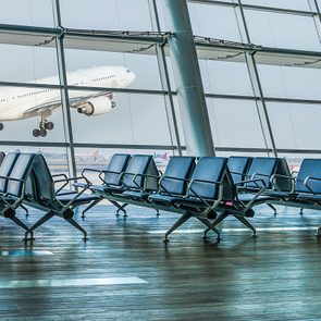 Empty airport departure lounge and airplane take off