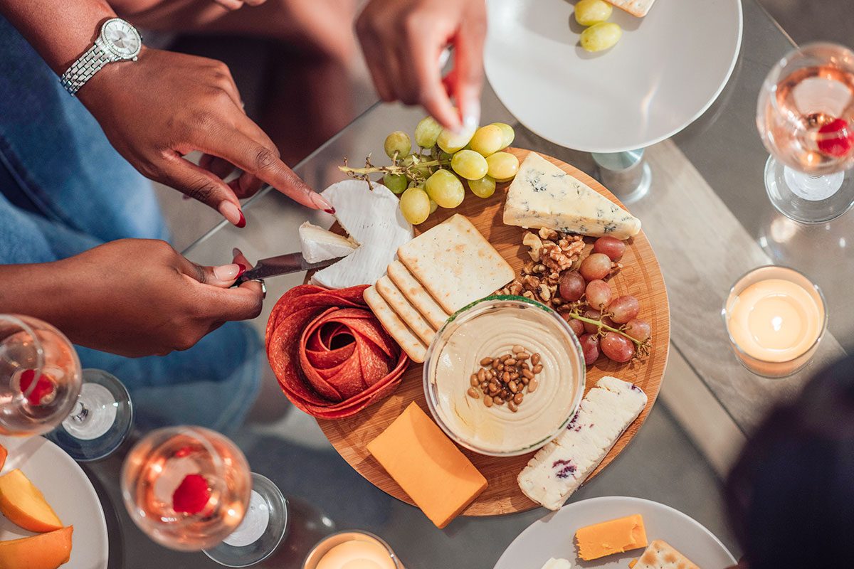 group of people enjoying a glass of wine and charcuterie board
