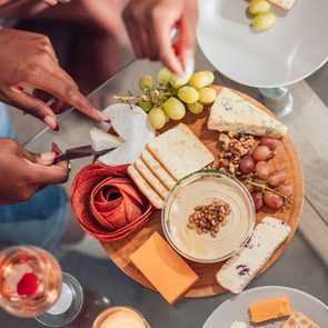 group of people enjoying a glass of wine and charcuterie board