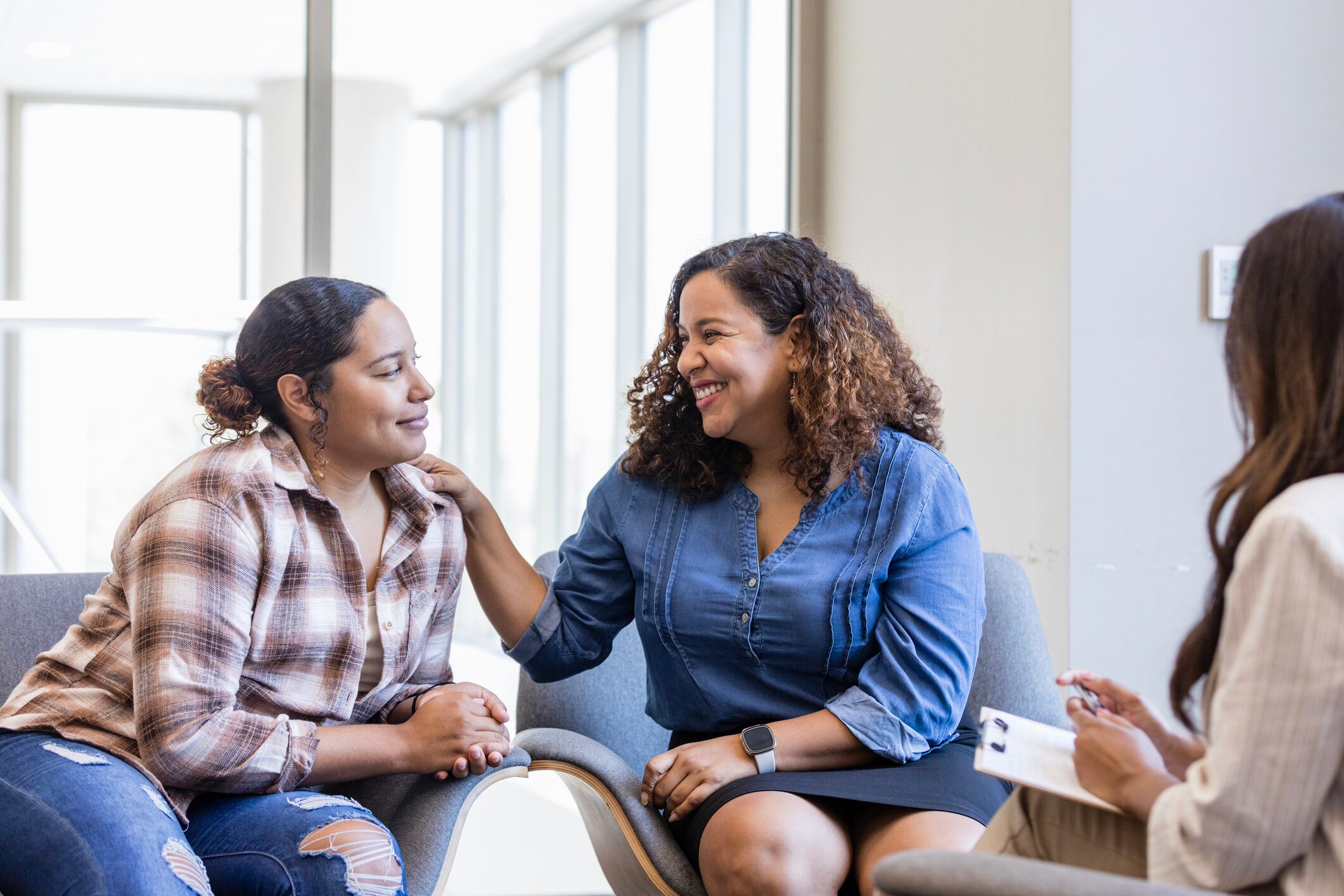 Mother smiles proudly at her daughter after telling the therapist how much she loves her