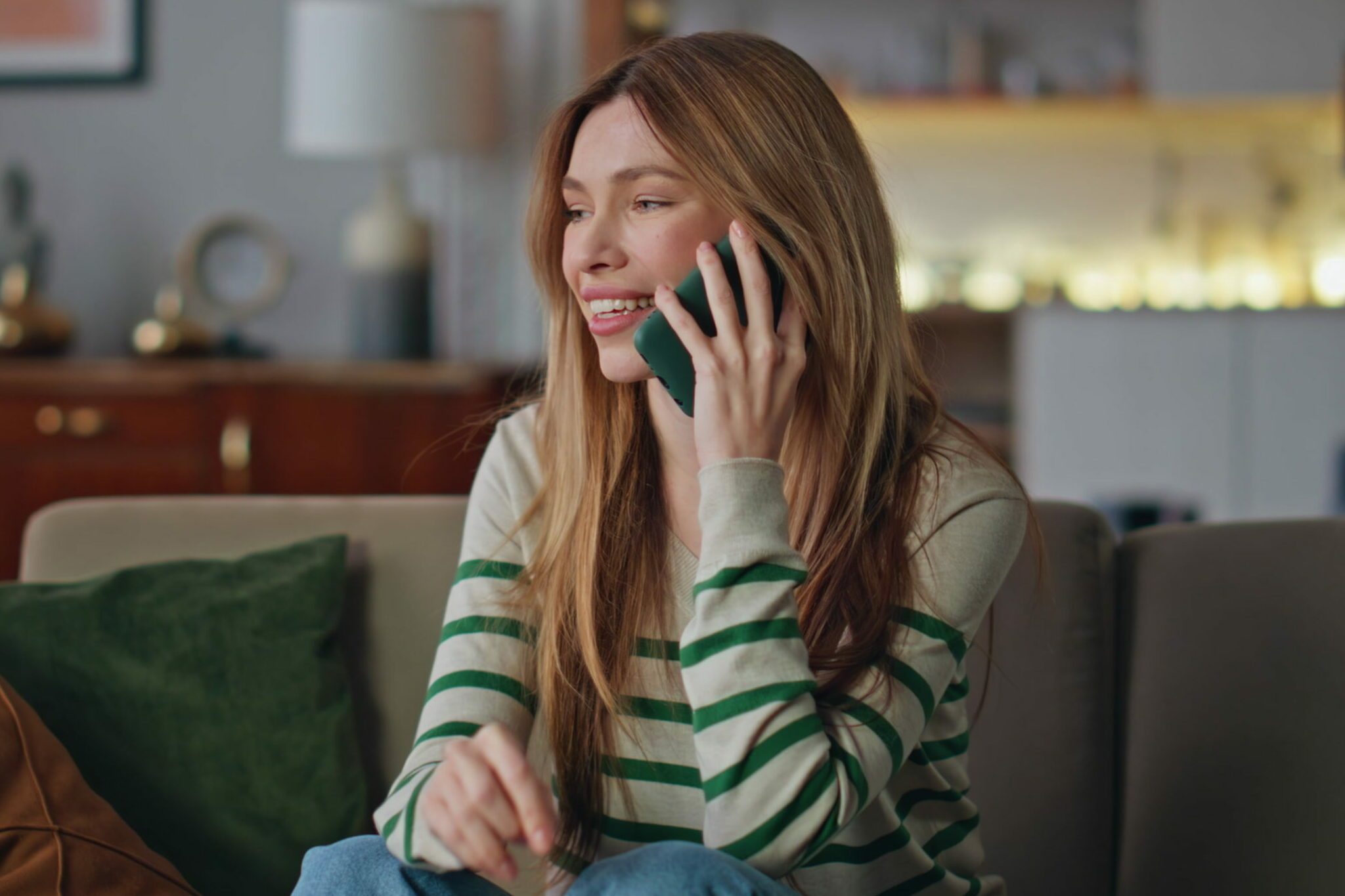 Smiling lady calling friends by smartphone at home close up. Happy woman talking